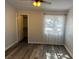 Cozy bedroom with gray wood flooring, closet, and window with sheer curtains for soft lighting at 7885 W Flamingo Rd # 2019, Las Vegas, NV 89147