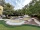 Backyard oasis with a decorative water feature surrounded by lush landscaping and artificial grass at 8138 Yucca Springs Dr, Las Vegas, NV 89129