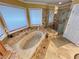 Bright bathroom featuring a jacuzzi bathtub with tile surround, a glass-enclosed shower and tile flooring at 8138 Yucca Springs Dr, Las Vegas, NV 89129