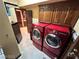Well-lit laundry room with custom wood cabinets, laundry machines, and views to other rooms in the home at 8138 Yucca Springs Dr, Las Vegas, NV 89129