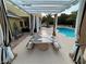 Covered patio area with decorative table, seating, and elegant striped curtains overlooking the pool at 8138 Yucca Springs Dr, Las Vegas, NV 89129