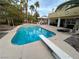 Inviting pool with diving board and hot tub surrounded by palm trees and lounge seating at 8138 Yucca Springs Dr, Las Vegas, NV 89129