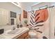 Charming bathroom shows a single sink, a toilet, and a shower with a decorative shower curtain at 8247 Oasis Bloom St, North Las Vegas, NV 89085