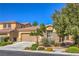 Inviting single-story house with a two-car garage, desert landscaping, and stone details at 8247 Oasis Bloom St, North Las Vegas, NV 89085