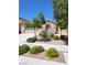 Charming home with desert landscaping, including shrubs, trees, and a rock garden, creating an inviting curb appeal at 8247 Oasis Bloom St, North Las Vegas, NV 89085