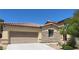 Home exterior features a two-car garage, stone accents, and a well-maintained yard, offering a blend of style and functionality at 8247 Oasis Bloom St, North Las Vegas, NV 89085