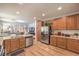 Open kitchen with stainless appliances, wood cabinets, and an island with seating at 8247 Oasis Bloom St, North Las Vegas, NV 89085