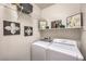 Clean laundry room with modern washer, dryer, shelving and decor at 8247 Oasis Bloom St, North Las Vegas, NV 89085
