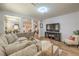 Comfortable living room showcasing a large sectional, TV, and view to the dining area at 8247 Oasis Bloom St, North Las Vegas, NV 89085