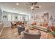 Open-concept living room with a ceiling fan, neutral decor, and wood-look floors at 8247 Oasis Bloom St, North Las Vegas, NV 89085