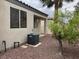 View of the backyard with rocks, a tree, and an AC unit next to the house at 8325 Aspen Village St, Las Vegas, NV 89113