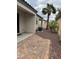 A brick patio in a backyard with rock landscaping, a palm tree, and a privacy fence at 8325 Aspen Village St, Las Vegas, NV 89113