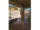 Inviting backyard with a stone patio, table set, privacy wall, and shady umbrella for outdoor living at 8345 Mozley Park St, Las Vegas, NV 89113