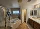 Bright bathroom featuring a soaking tub with tile surround, glass enclosed shower, and wood vanity at 8345 Mozley Park St, Las Vegas, NV 89113