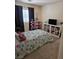 Bedroom with patterned bedspread, shelving unit, and a sunny window at 8345 Mozley Park St, Las Vegas, NV 89113