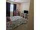 Bedroom with a patterned bedspread, shelving with books, and a window with curtains at 8345 Mozley Park St, Las Vegas, NV 89113