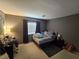 Bedroom featuring a bed, nightstand, window with curtains, and a work desk at 8345 Mozley Park St, Las Vegas, NV 89113