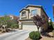 View of home's exterior featuring an attached two-car garage and mature landscaping at 8345 Mozley Park St, Las Vegas, NV 89113