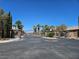 View of the community gate with decorative stone pillars and mature landscaping at 8345 Mozley Park St, Las Vegas, NV 89113