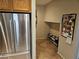 Hallway featuring a stainless steel refrigerator and shoe rack, with tile flooring at 8345 Mozley Park St, Las Vegas, NV 89113
