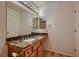 Bathroom features a granite vanity, a large mirror and bright lighting at 8613 Linderwood Dr, Las Vegas, NV 89134