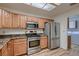Bright kitchen features stainless steel appliances and wooden cabinets with adjacent laundry area at 8613 Linderwood Dr, Las Vegas, NV 89134