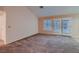 Comfortable living room with plush carpeting, neutral paint and access to the outdoors at 8613 Linderwood Dr, Las Vegas, NV 89134