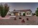 Rear exterior of the home offers desert landscaping, rock detail and a covered patio, inviting outdoor enjoyment at 8613 Linderwood Dr, Las Vegas, NV 89134