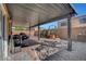 Covered patio with brick flooring, featuring outdoor furniture, grill and dog house at 9065 W Torino Ave, Las Vegas, NV 89148