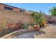 Fully fenced backyard with mature shrubs, brick pavers, and a classic red bicycle against the wall at 9065 W Torino Ave, Las Vegas, NV 89148