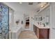 Bathroom boasts double sinks, an alcove tub, and a beautifully designed glass shower door at 9065 W Torino Ave, Las Vegas, NV 89148