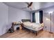 The bedroom features dark curtains, wood floors, a ceiling fan, and a simple yet elegant design at 9065 W Torino Ave, Las Vegas, NV 89148