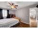 Cozy bedroom with ceiling fan and wood laminate flooring, and view to living room at 9065 W Torino Ave, Las Vegas, NV 89148