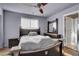 Well-lit bedroom featuring a ceiling fan, laminate floors, double closet, and neutral wall color at 9065 W Torino Ave, Las Vegas, NV 89148