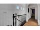 Hallway features black railing, light walls, and wood-style floors at 9065 W Torino Ave, Las Vegas, NV 89148