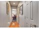 Hallway featuring wood flooring and artwork leading to a room with an office space and a vanity table at 9065 W Torino Ave, Las Vegas, NV 89148