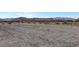 View of a vacant lot with desert landscape and mountain views in the background at 9065 W Torino Ave, Las Vegas, NV 89148