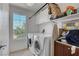 Bright laundry room equipped with front loading washer and dryer, ample storage, and a window at 9065 W Torino Ave, Las Vegas, NV 89148