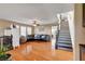 Open living room featuring a staircase, hardwood floors, and a comfortable sectional sofa with a ceiling fan at 9065 W Torino Ave, Las Vegas, NV 89148