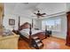 This bright main bedroom features a ceiling fan, wood floors, and a beautiful window providing exterior views at 9065 W Torino Ave, Las Vegas, NV 89148