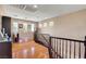 Upstairs hallway with hardwood floors, staircase railing, and windows with views of the neighborhood at 9065 W Torino Ave, Las Vegas, NV 89148