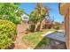 Landscaped backyard features green grass, a small patio, mature trees and ample space for outdoor activities at 9324 Freedom Heights Ave, Las Vegas, NV 89149
