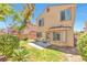 The cozy backyard features lush greenery, a patio, and a charming two-story home with bright, sunlit windows at 9324 Freedom Heights Ave, Las Vegas, NV 89149