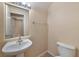 Cozy powder room featuring a pedestal sink, toilet, and wood-look flooring at 9324 Freedom Heights Ave, Las Vegas, NV 89149