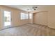 Spacious bedroom with a ceiling fan, carpet, and a door leading to the backyard at 9324 Freedom Heights Ave, Las Vegas, NV 89149