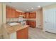 Well-lit kitchen with wood cabinets, granite countertops, and tile flooring at 9324 Freedom Heights Ave, Las Vegas, NV 89149