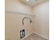 Functional laundry room with hookups, storage shelf, and updated flooring at 9324 Freedom Heights Ave, Las Vegas, NV 89149