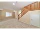 Bright living area showcasing a staircase with wood railings, large windows, and neutral carpet flooring at 9324 Freedom Heights Ave, Las Vegas, NV 89149