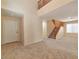 Spacious living room with carpet flooring, neutral paint, and an open staircase, creating a bright atmosphere at 9324 Freedom Heights Ave, Las Vegas, NV 89149