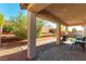 Relaxing covered patio with brick pavers, complemented by a landscaped backyard with small trees at 10742 Cowlite Ave, Las Vegas, NV 89166